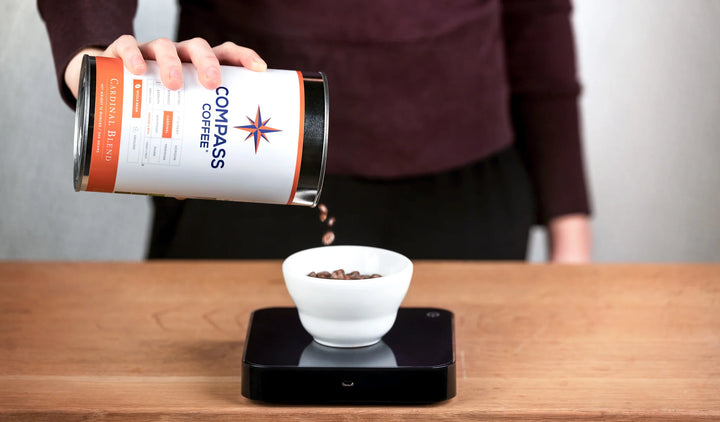 A barista pulls a perfect shot of Emblem Espresso into Compass Coffee's patented Real Good Coffee mug.