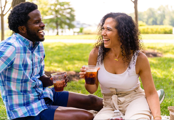 two-people-in-park-enjoying-compass-coffee-iced-drinks